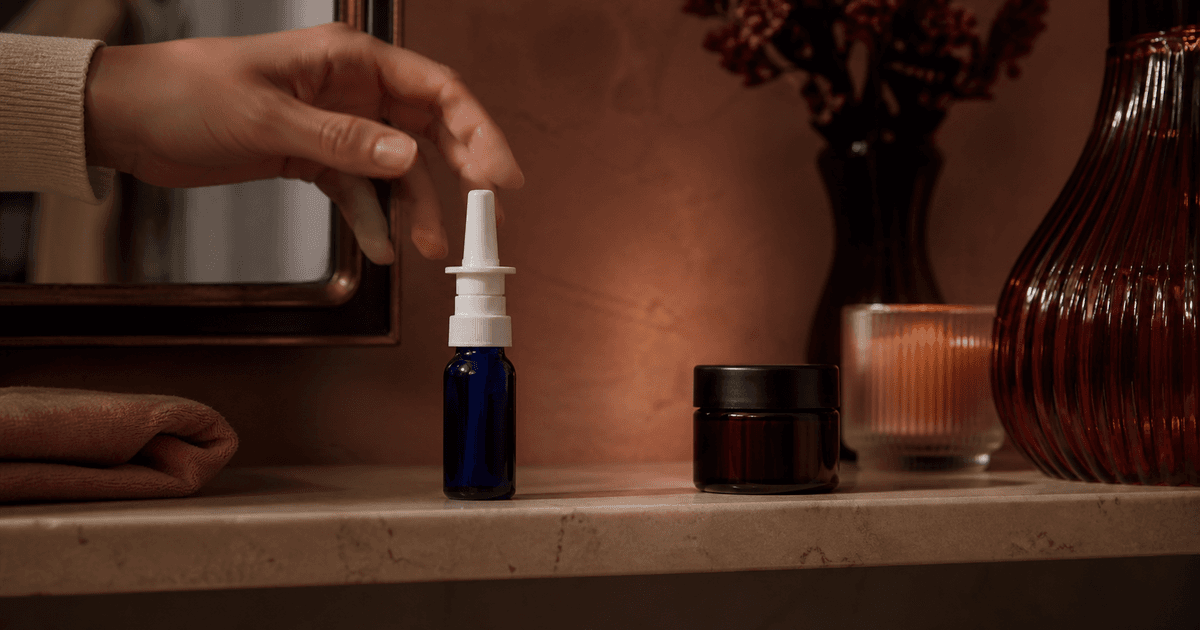 Unbranded PT-141 nasal bottle and mini-troche jar in warm black-cherry evening light