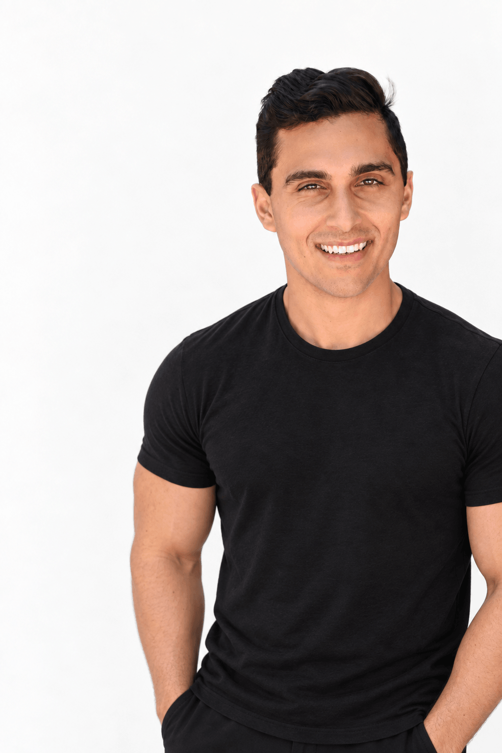 Nick Locascio smiling in a black T-shirt against a light studio background.