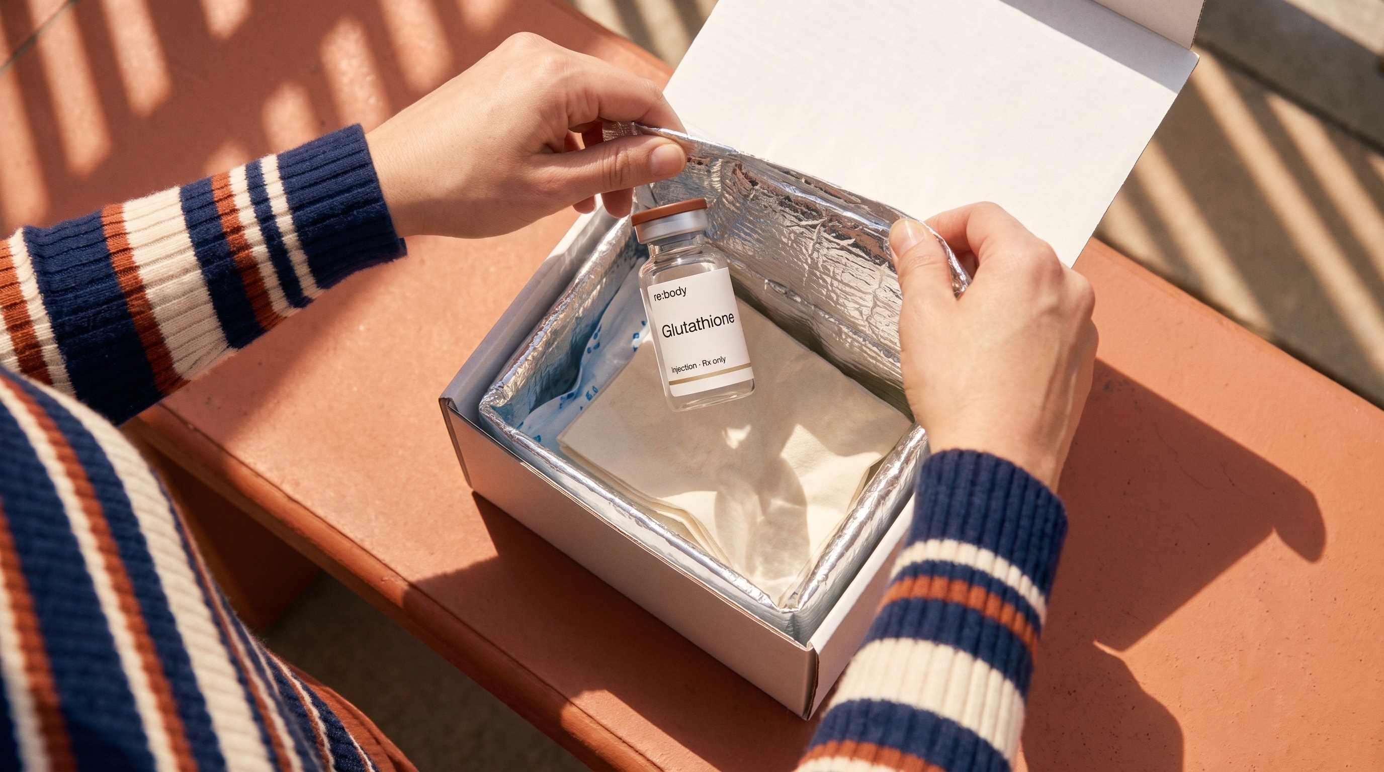 A cold-packed Rebody glutathione kit in warm sunlight.