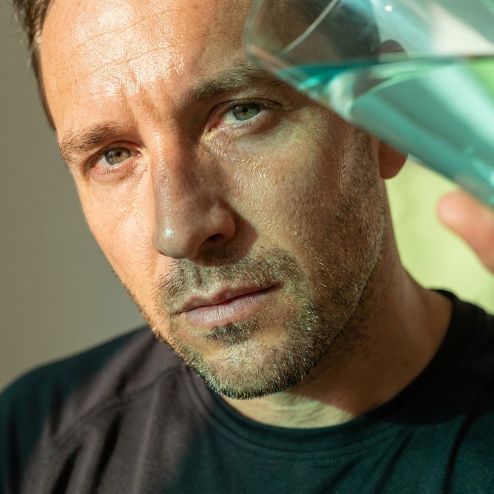 Close, calm focused adult face crop with refracted light.