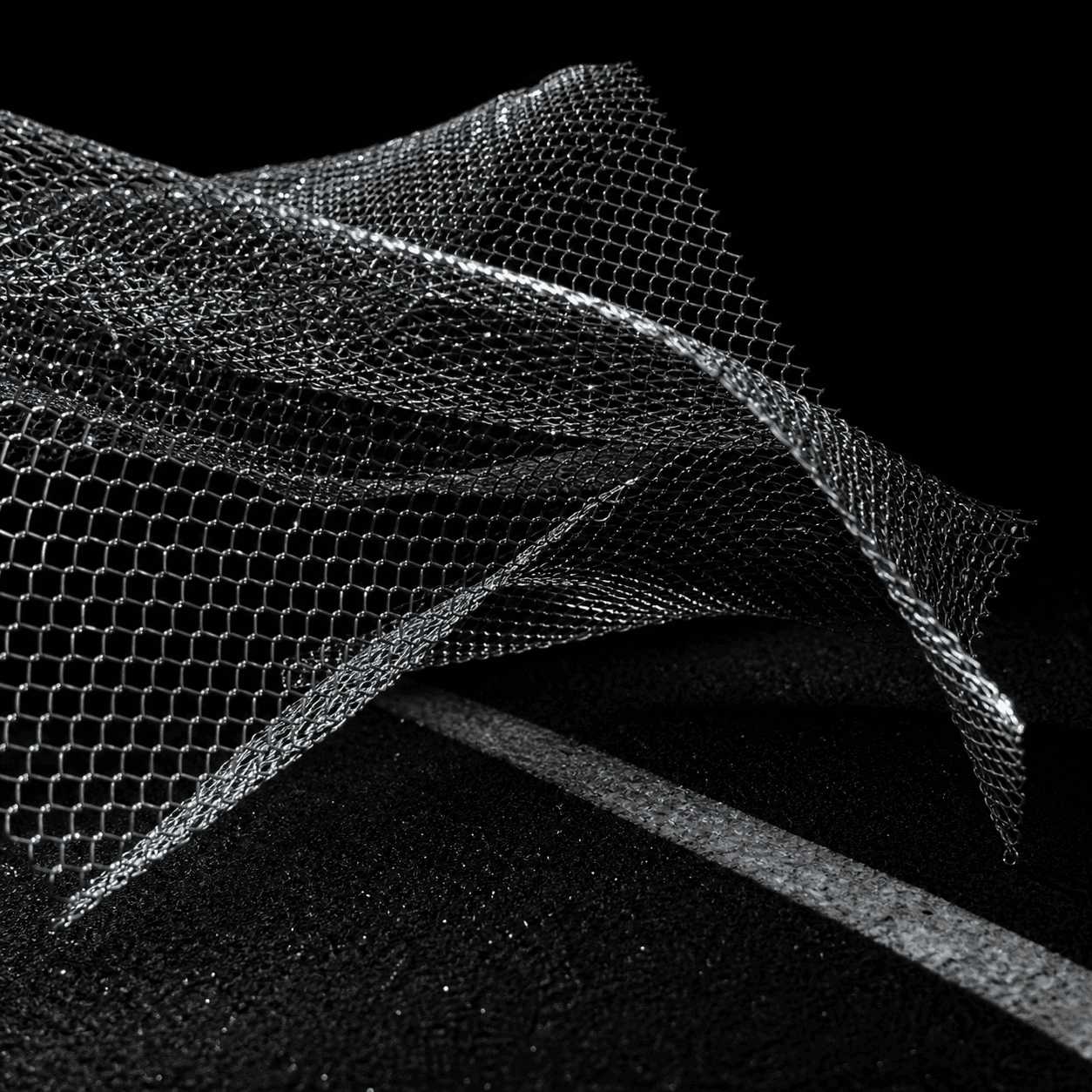 Silver chain mesh folding over a dark running surface