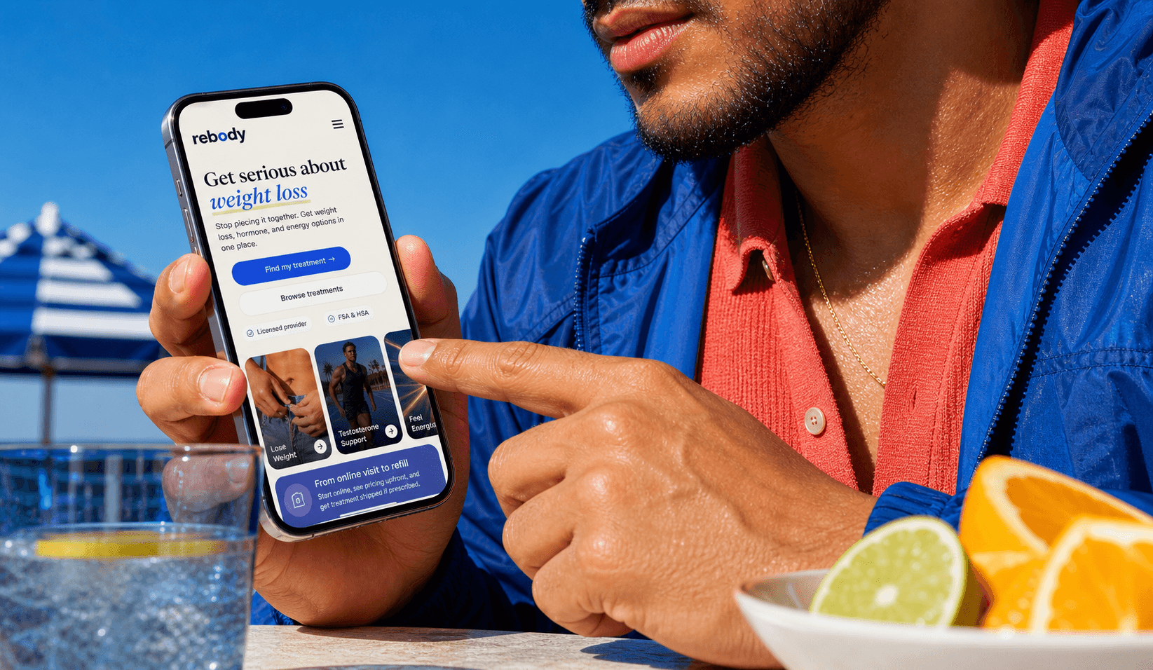 Man in a cobalt jacket viewing the Rebody mobile homepage on a smartphone.