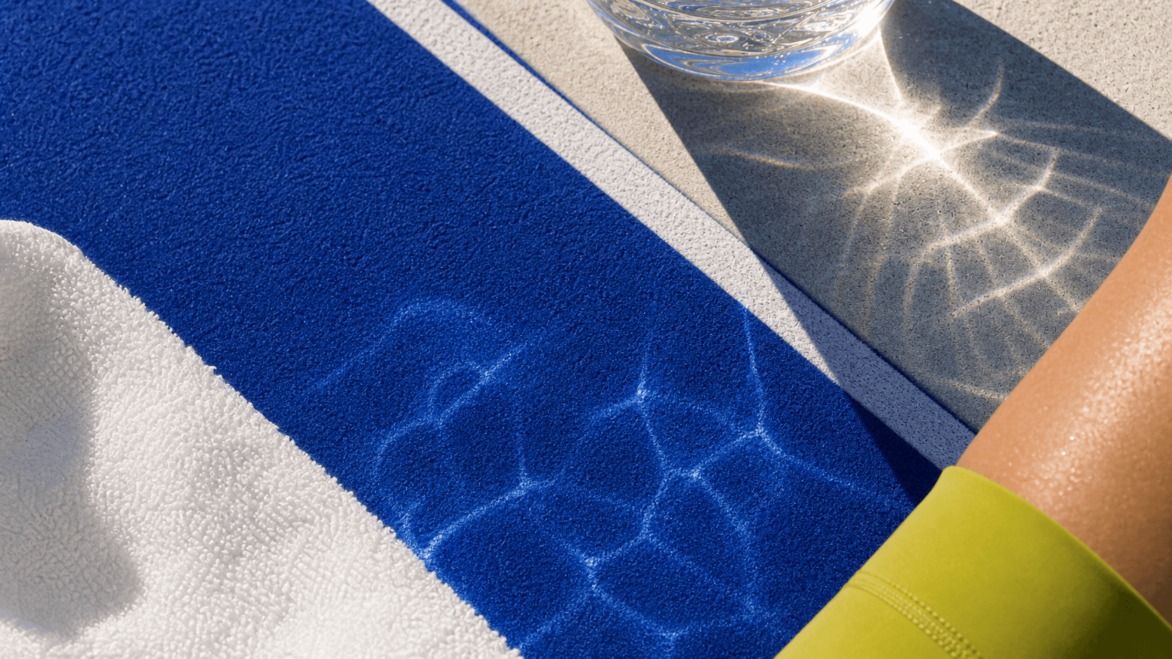 Abstract sunlit cobalt track texture with water refraction, towel fibers, and activewear detail.