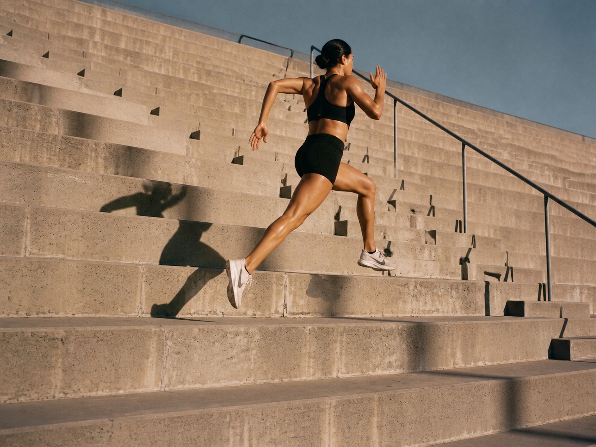 Runner bounding up a long flight of concrete stairs.