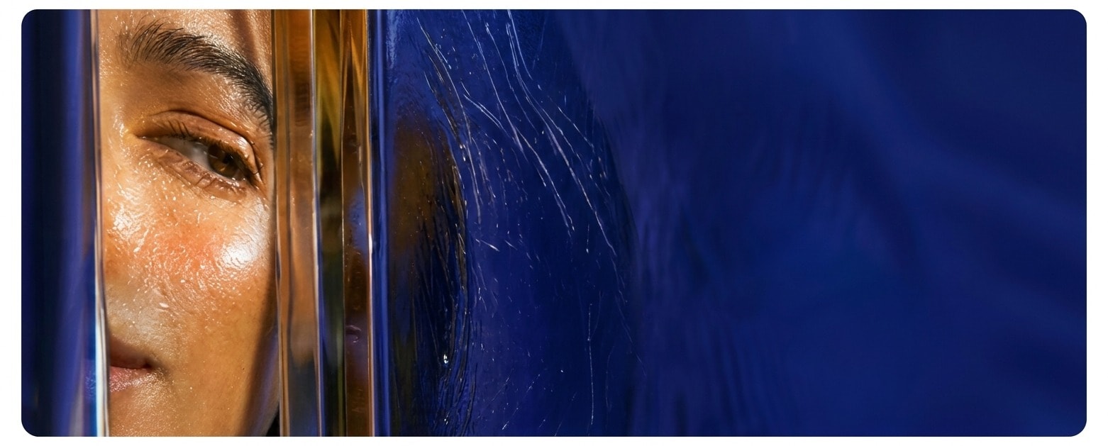 Woman beside refractive glass on a cobalt background