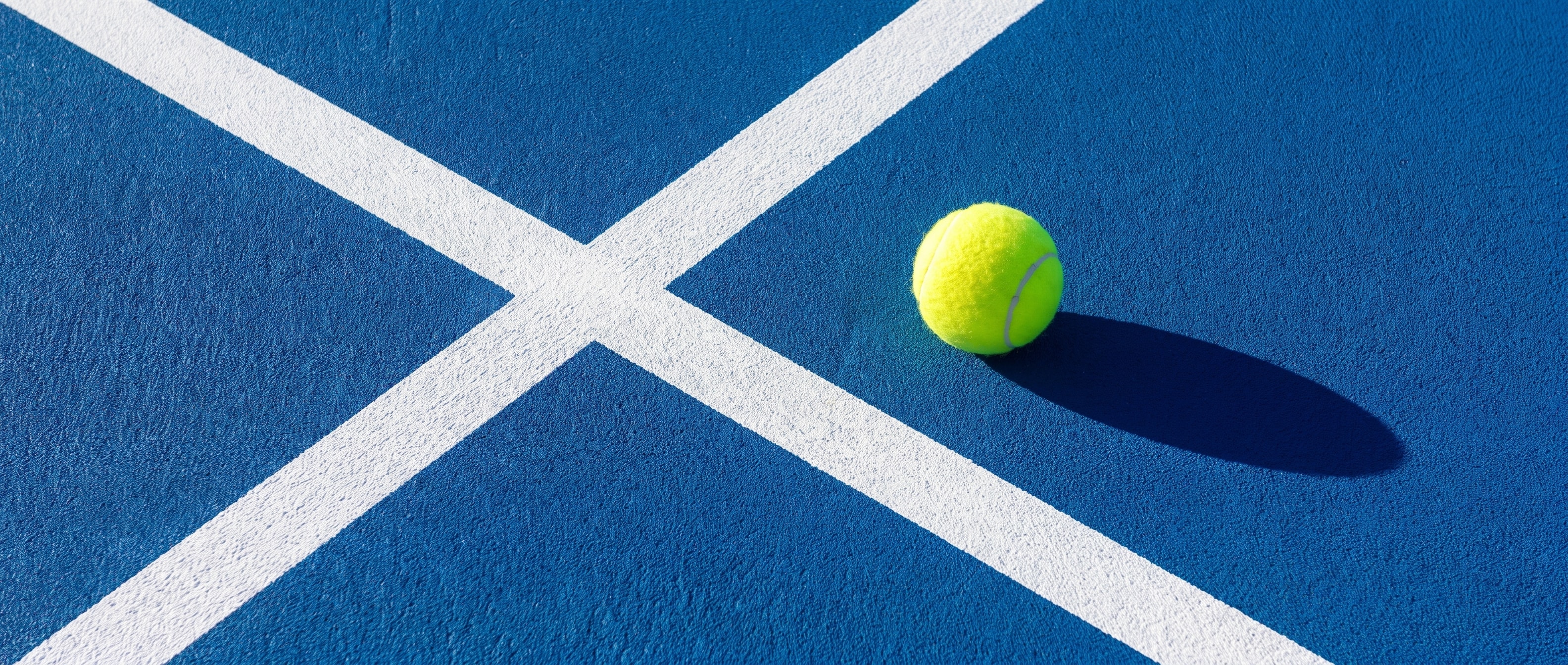 Tennis ball on cobalt court