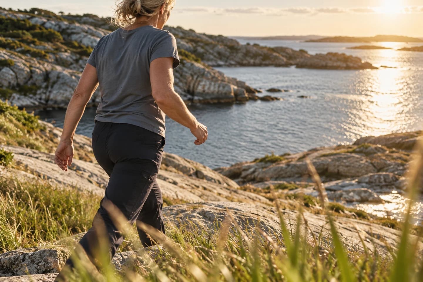 An adult walking across a coastal landscape