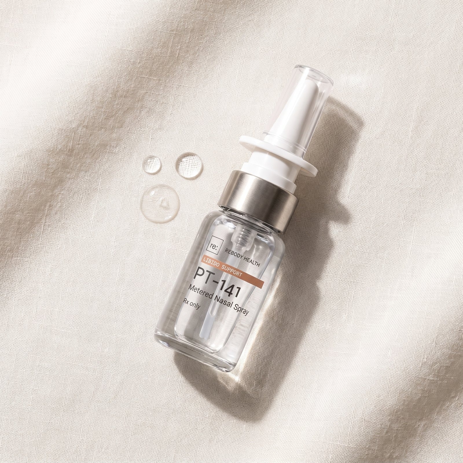 A closed package of pt-141 nasal spray lying on cream linen, seen from above.