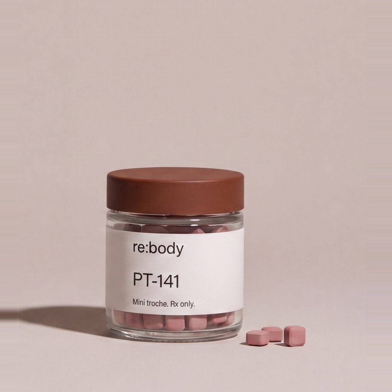A small glass jar of rose-coloured PT-141 mini troches with a clay-brown cap.