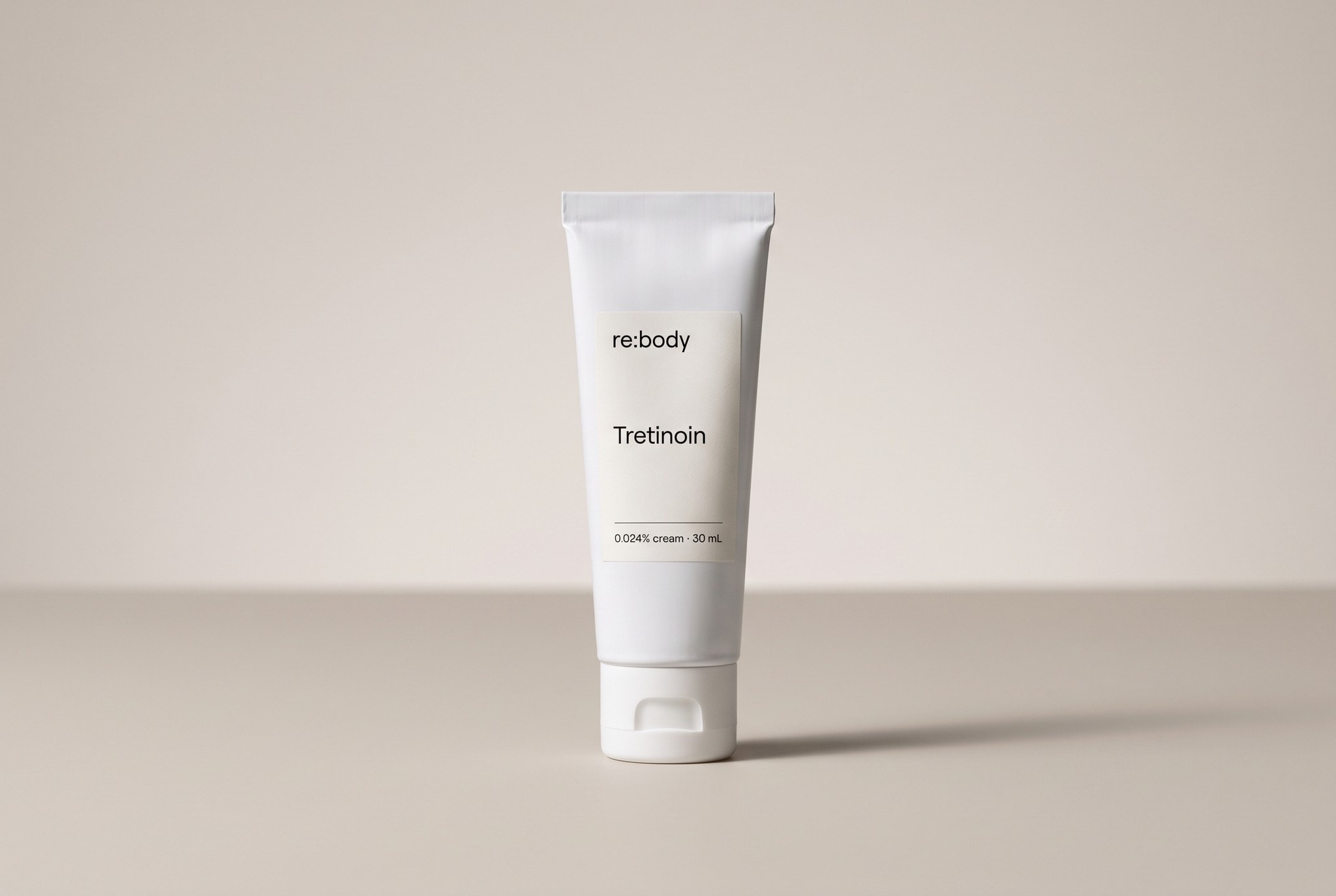 A white Rebody tube of tretinoin 0.024% cream, 30 mL, on a warm stone backdrop.