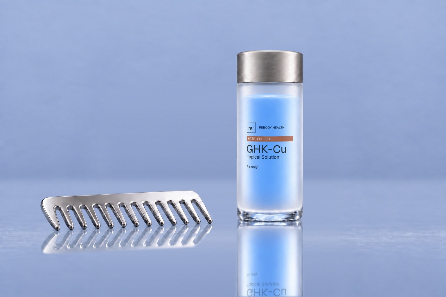 Frosted Rebody GHK-Cu hair-solution bottle beside a comb on a glossy slate-blue surface.