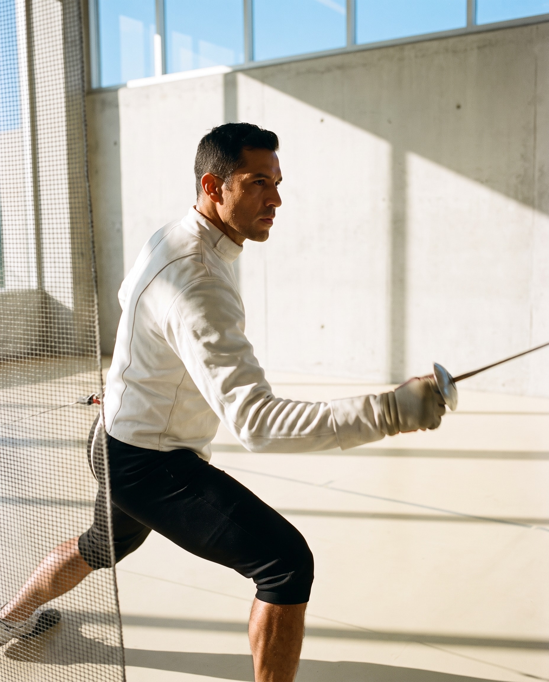 Man pausing after training as refracted light crosses a cobalt court.