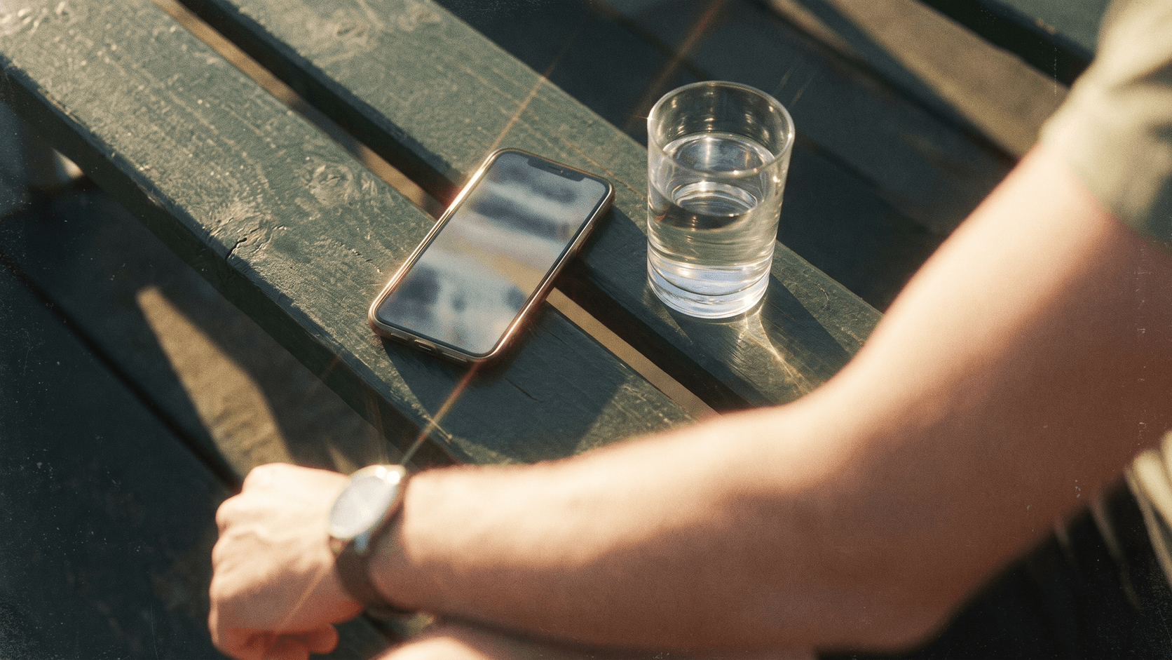 Smartphone showing a care-team message thread beside a towel and glass of water on a blue track.